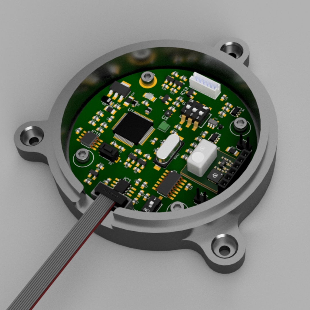 Close-up of a SEVEN9 electronics enclosure with populated PCB, showing microcontroller, connectors, and ribbon cable